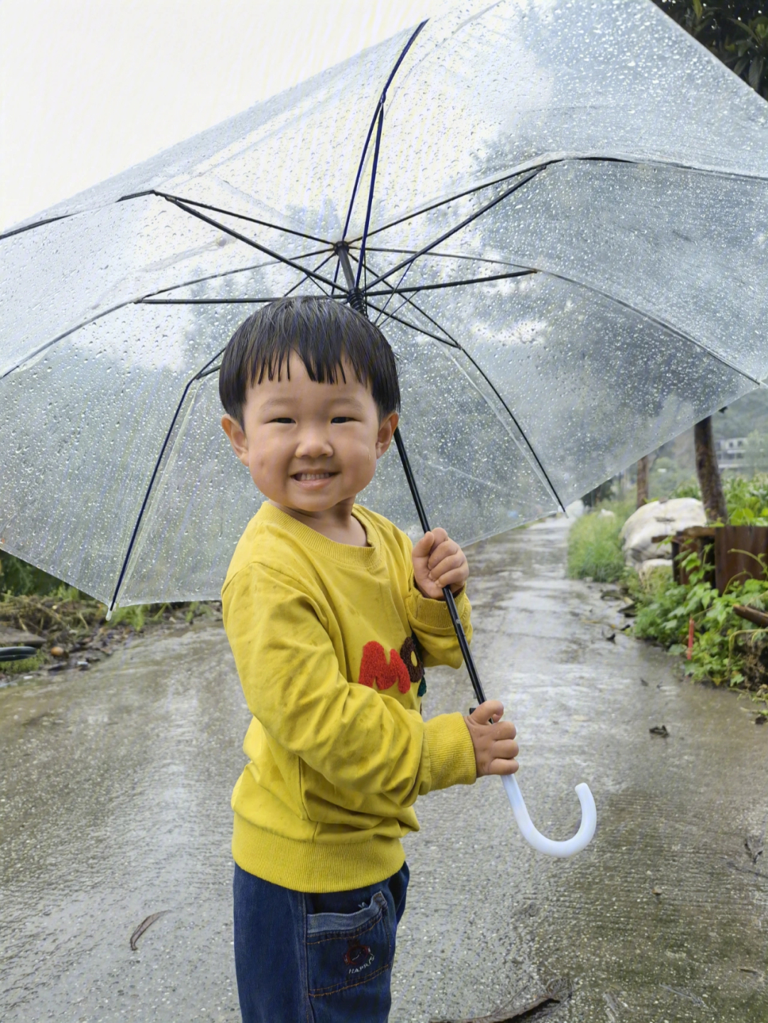 下雨中的小朋友第一次打雨伞玩水