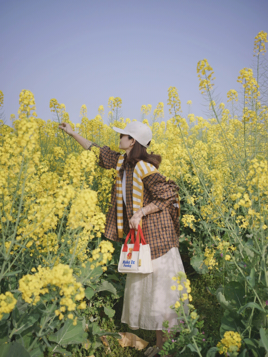 油菜花地拍照穿驼色图片