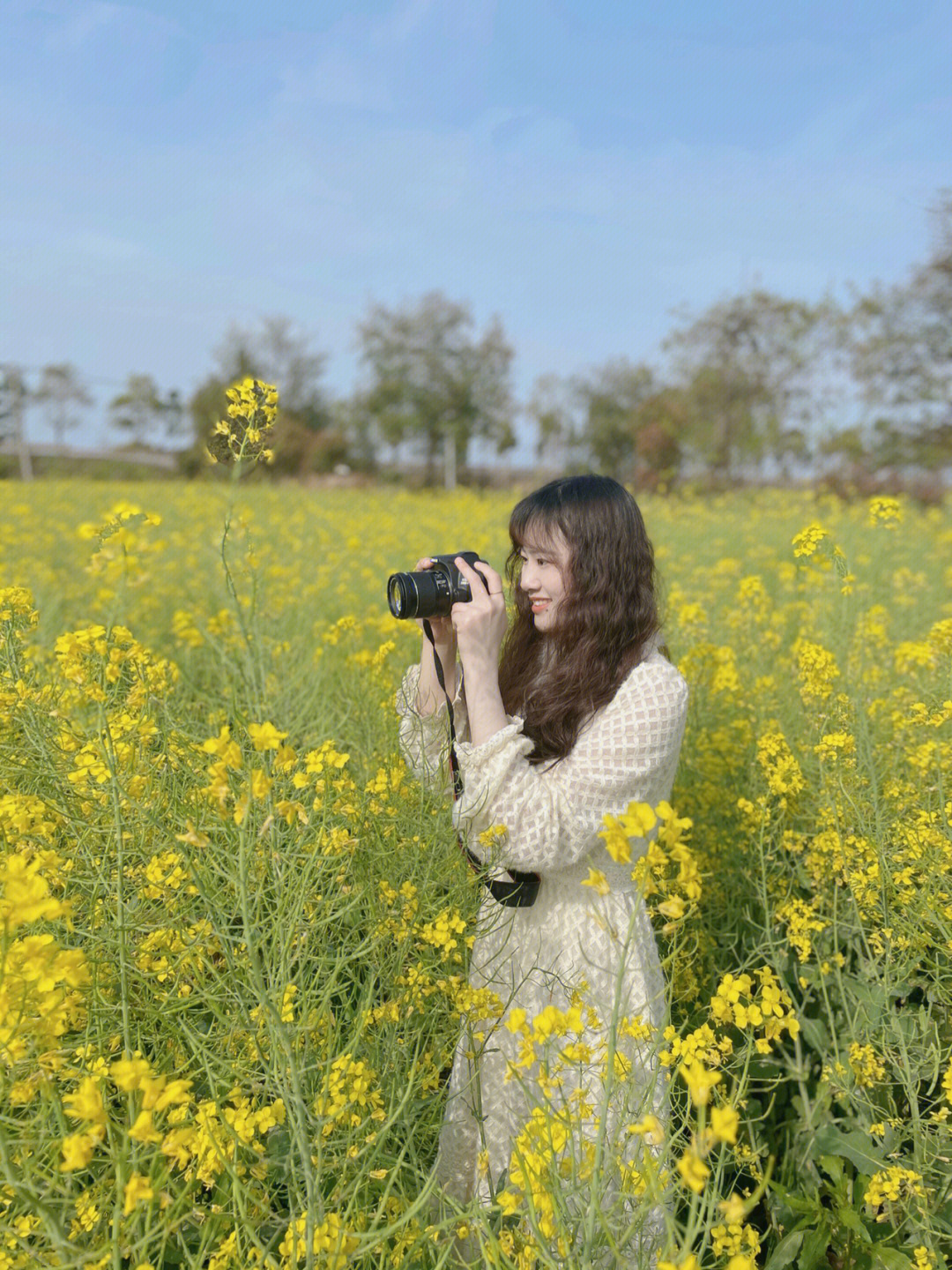 油菜花地拍照穿驼色图片