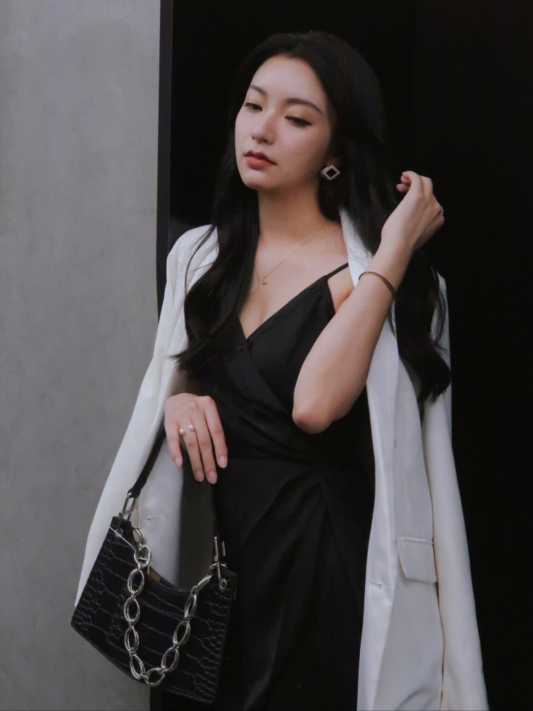黑色缎面吊带裙,搭配稍大的白色西装外套选择有垫肩的西装会更具更