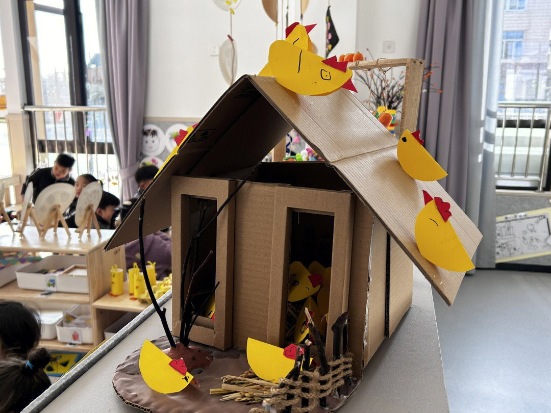 用纸箱做的鸡窝,里面的小鸡是小朋友自己制作的,房子里铺上了一层稻草