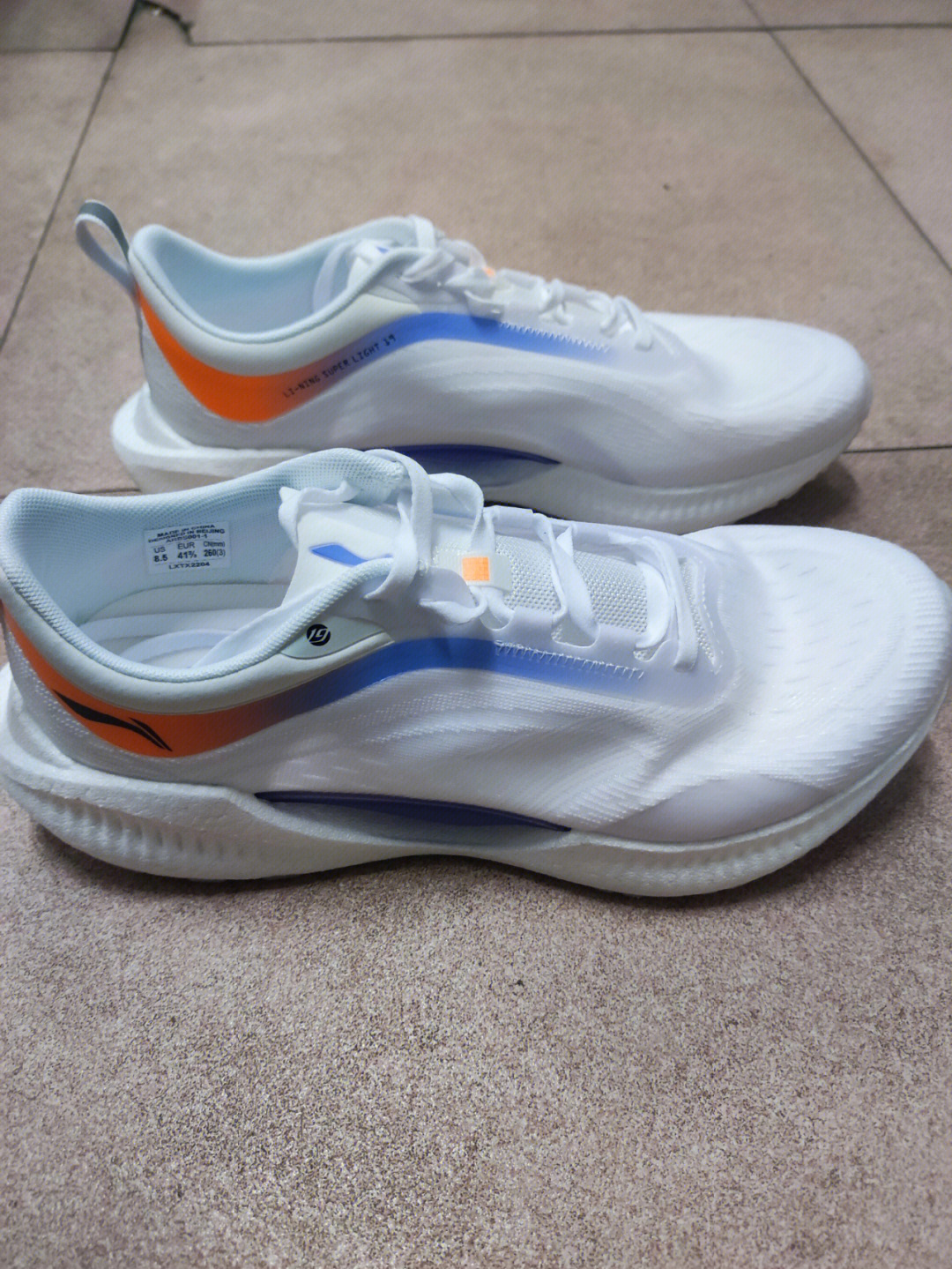 李宁跑鞋外观方面:鞋面轻薄且透气,大面积白色鞋身搭配蓝,橙色的脸